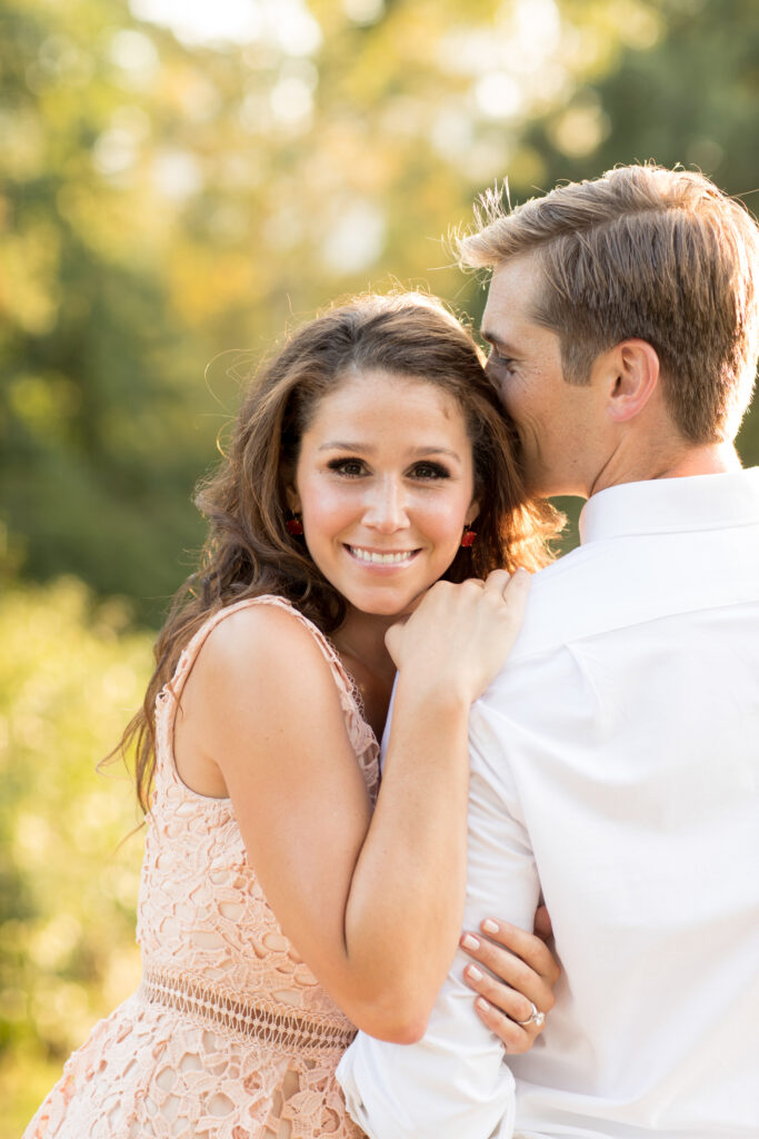 engaged couple with fall leaves in background