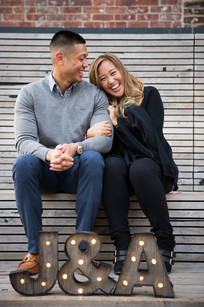 Couple laughing sitting on wood benches on the highline in NYC