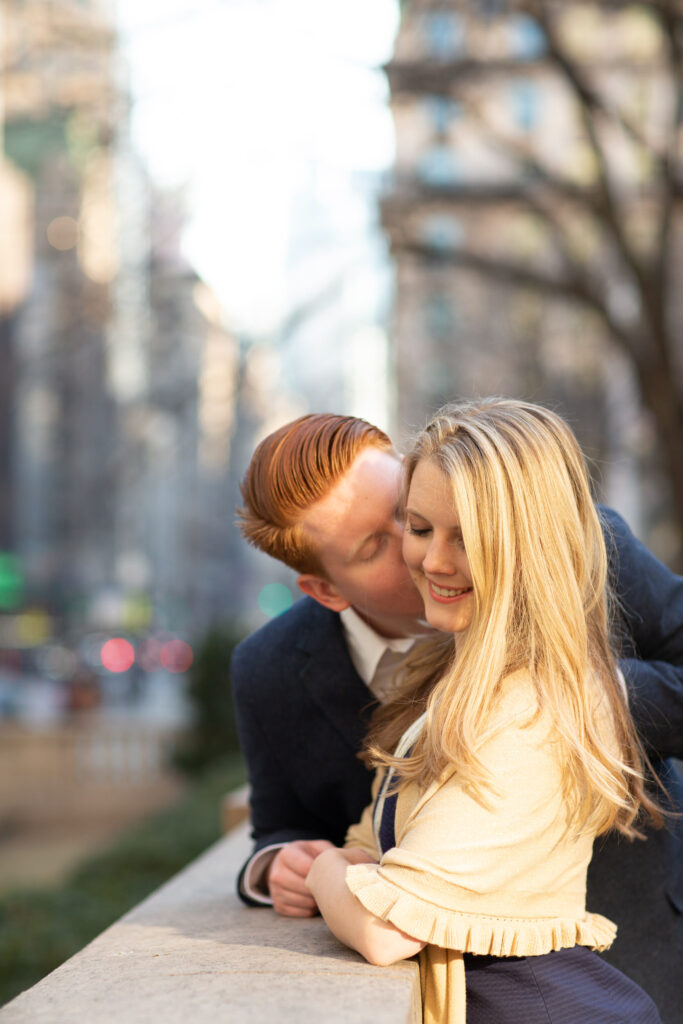 engaged couple in front of NY Public Library facing 5th Ave.