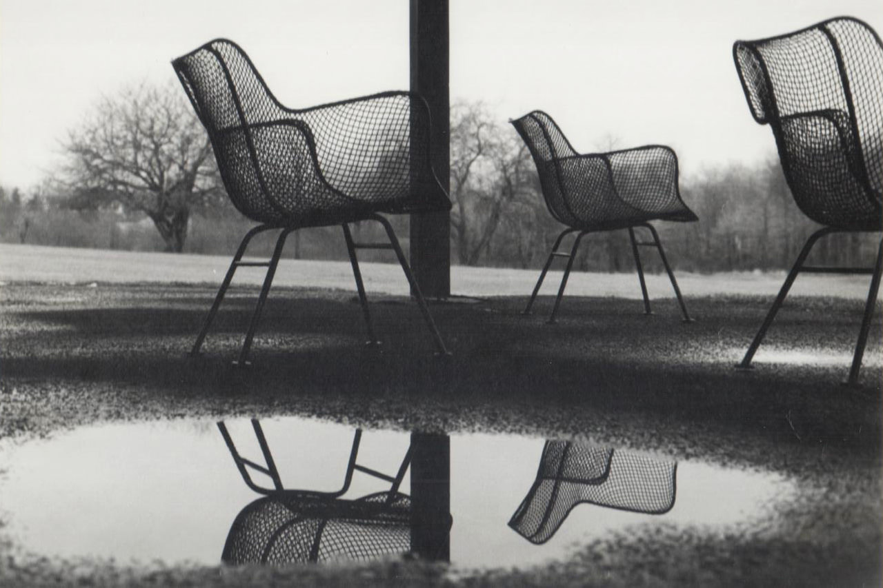 black and white wire chairs next to puddle