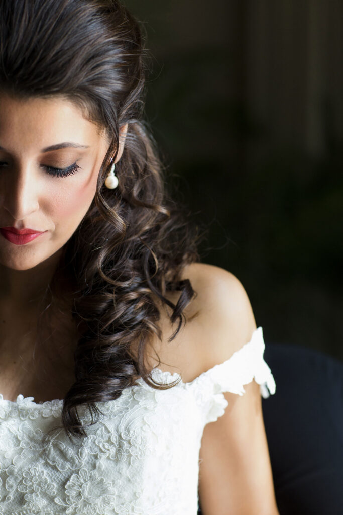 gorgeous high end bride looking down as she finished getting dressed