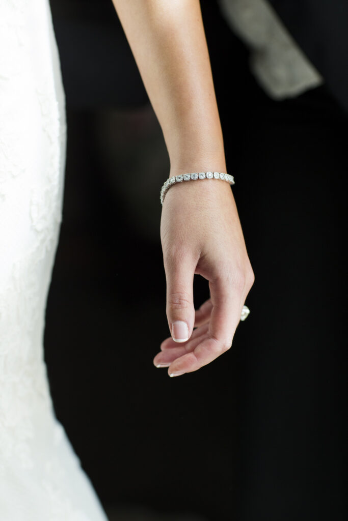 detailed photo of stunning bride's bracelet on her wrist as her arm is draped at her side
