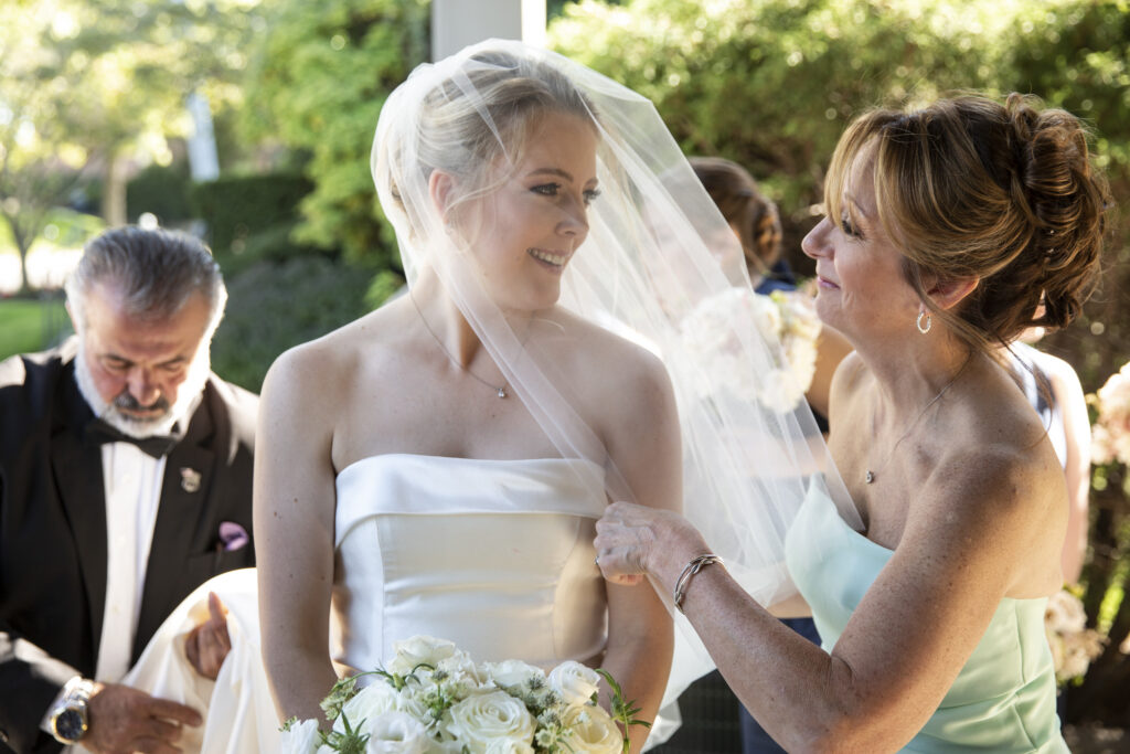 bride with her mom adjusting her veil before she walks into her church ceremony